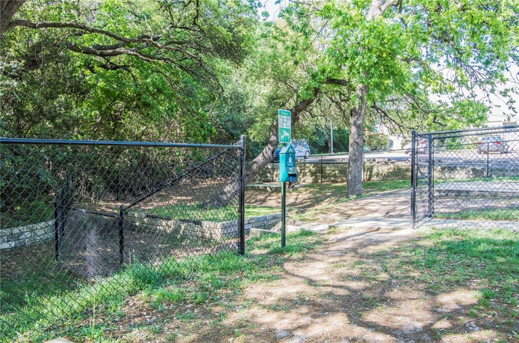 3204 Manchaca Road, Unit 302 Austin, TX 78704 - Photo 18 of 20 Mature trees shade a fenced community dog park area with a convenient waste station.