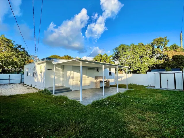 a view of a chair and table in backyard of the house