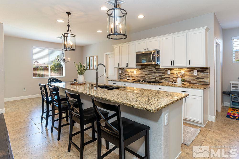 9825 Copenhagen Way Reno, NV 89521 - Photo 7 of 35 a kitchen with granite countertop kitchen island stainless steel appliances a dining table chairs sink and cabinets