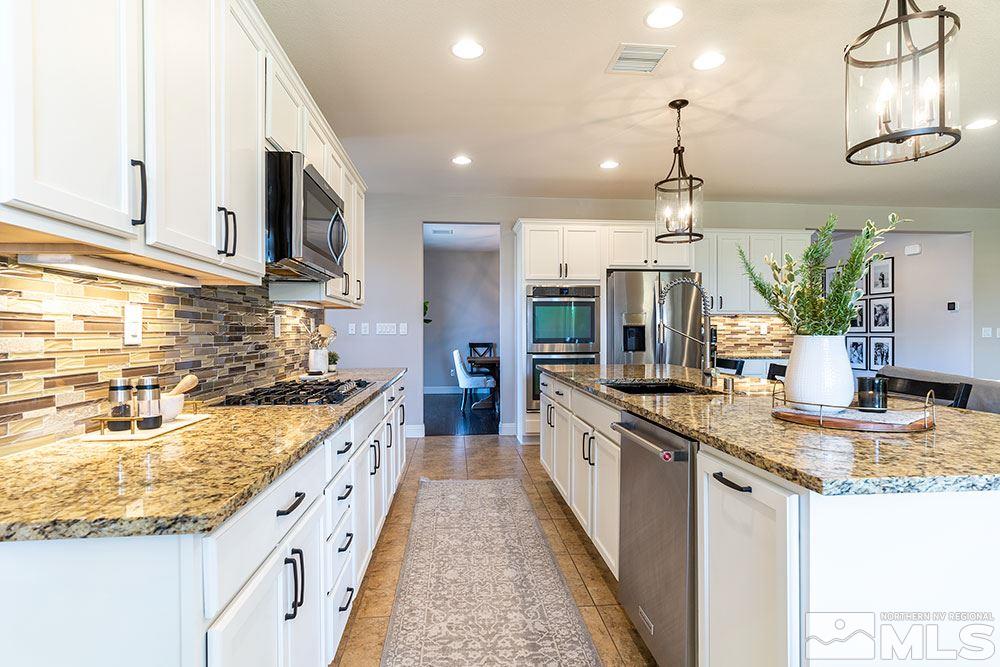 9825 Copenhagen Way Reno, NV 89521 - Photo 8 of 35 a kitchen with stainless steel appliances granite countertop a sink a stove and a wooden floors