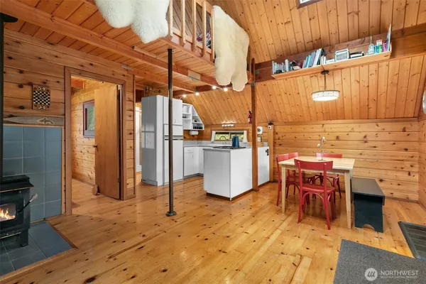 a kitchen with stainless steel appliances kitchen island granite countertop a table chairs and a refrigerator