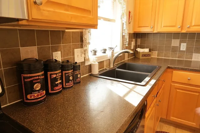 a view of a sink and dishwasher with wooden floor