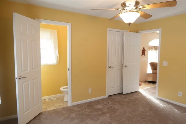 an empty room with windows and bathroom view