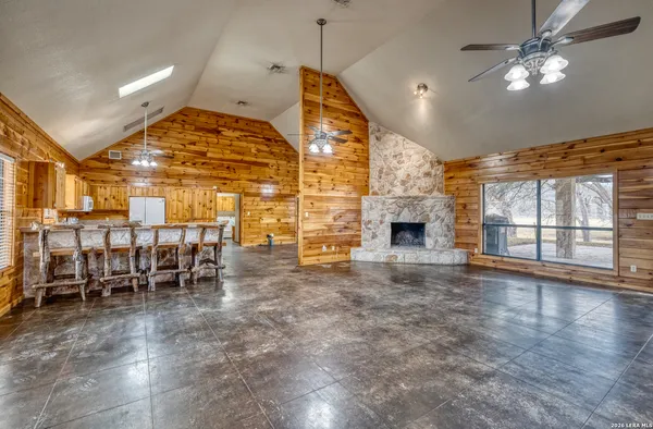 an empty room with fireplace chandelier and windows