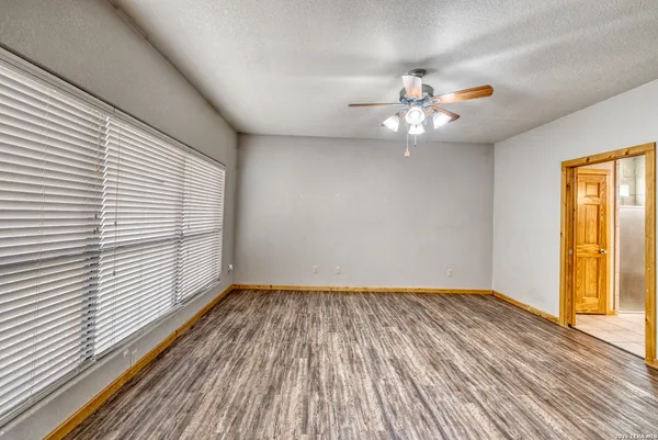 a view of a room with wooden floor and a ceiling fan