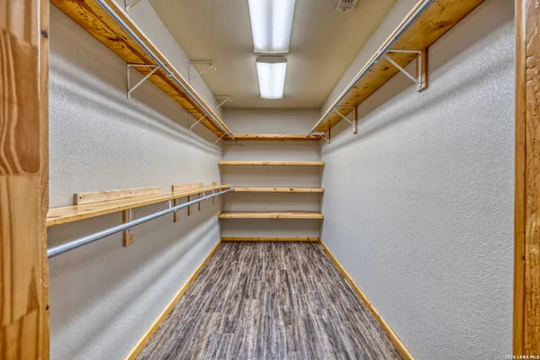 a view of closet with wooden floor