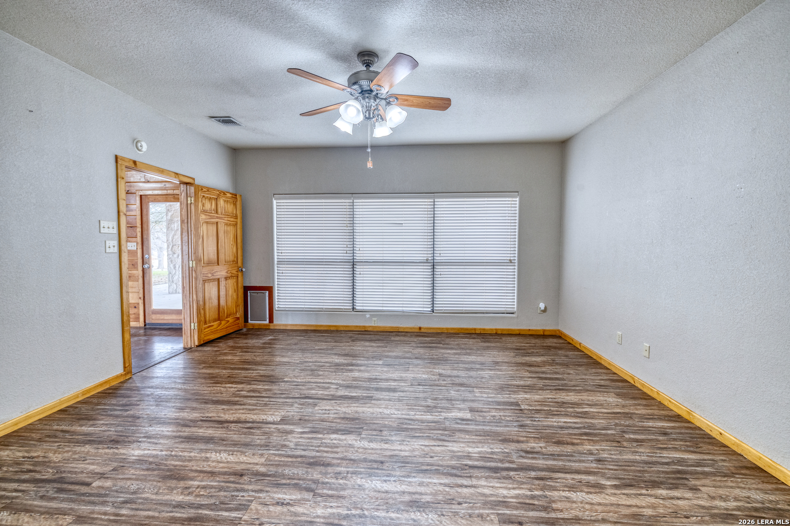 498 Camino Del Rancho Concan, TX 78838 - Photo 24 of 49 a view of an empty room with a window and wooden floor