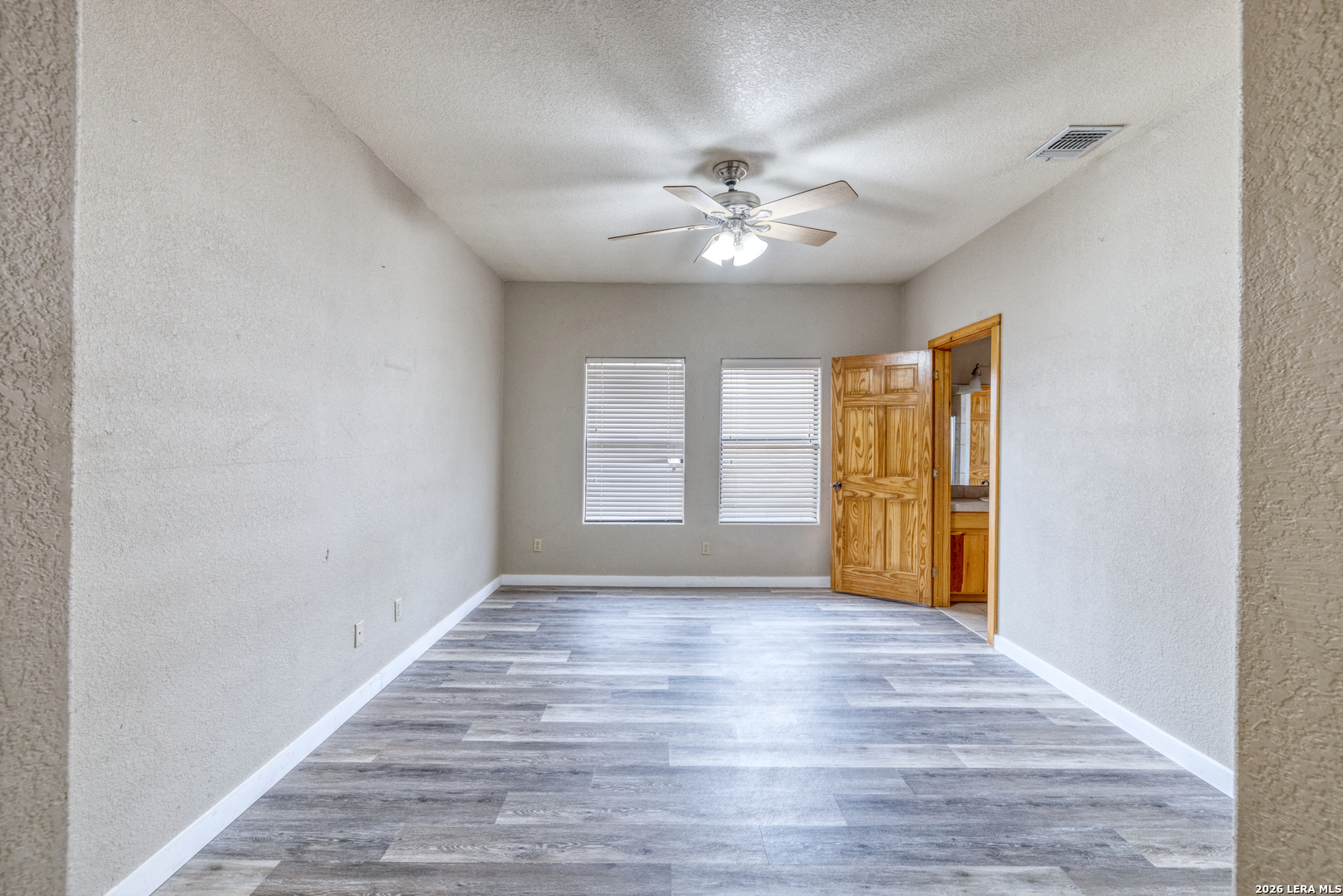 498 Camino Del Rancho Concan, TX 78838 - Photo 28 of 49 a view of an empty room with a window and wooden floor