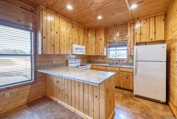 a kitchen with stainless steel appliances granite countertop a sink and a refrigerator
