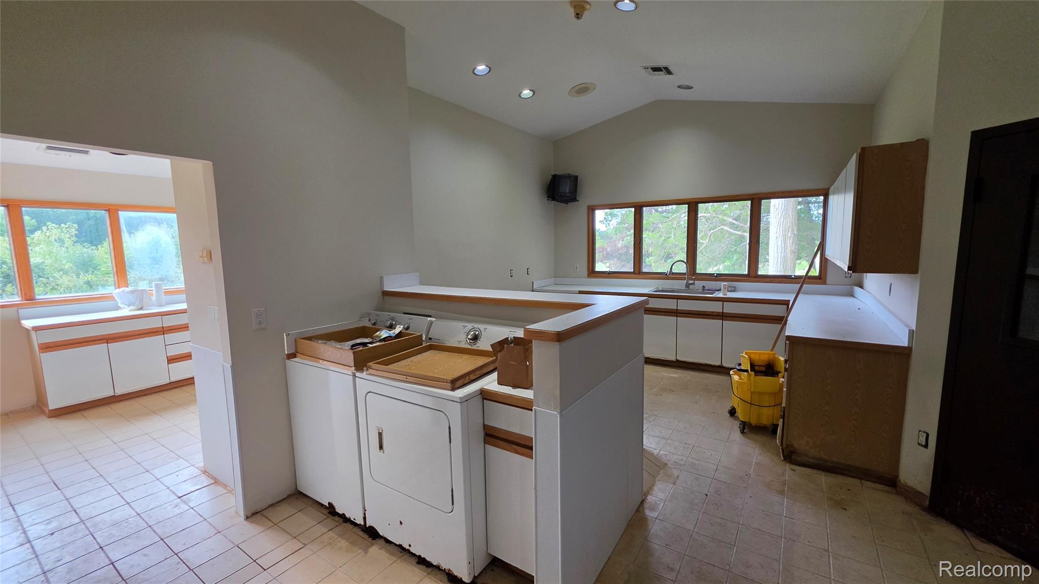 2551 Patterson Lk Road Pinckney, MI 48169 - Photo 28 of 37 Kennel. Spacious utility area featuring a washer and dryer, tile flooring, and integrated cabinetry