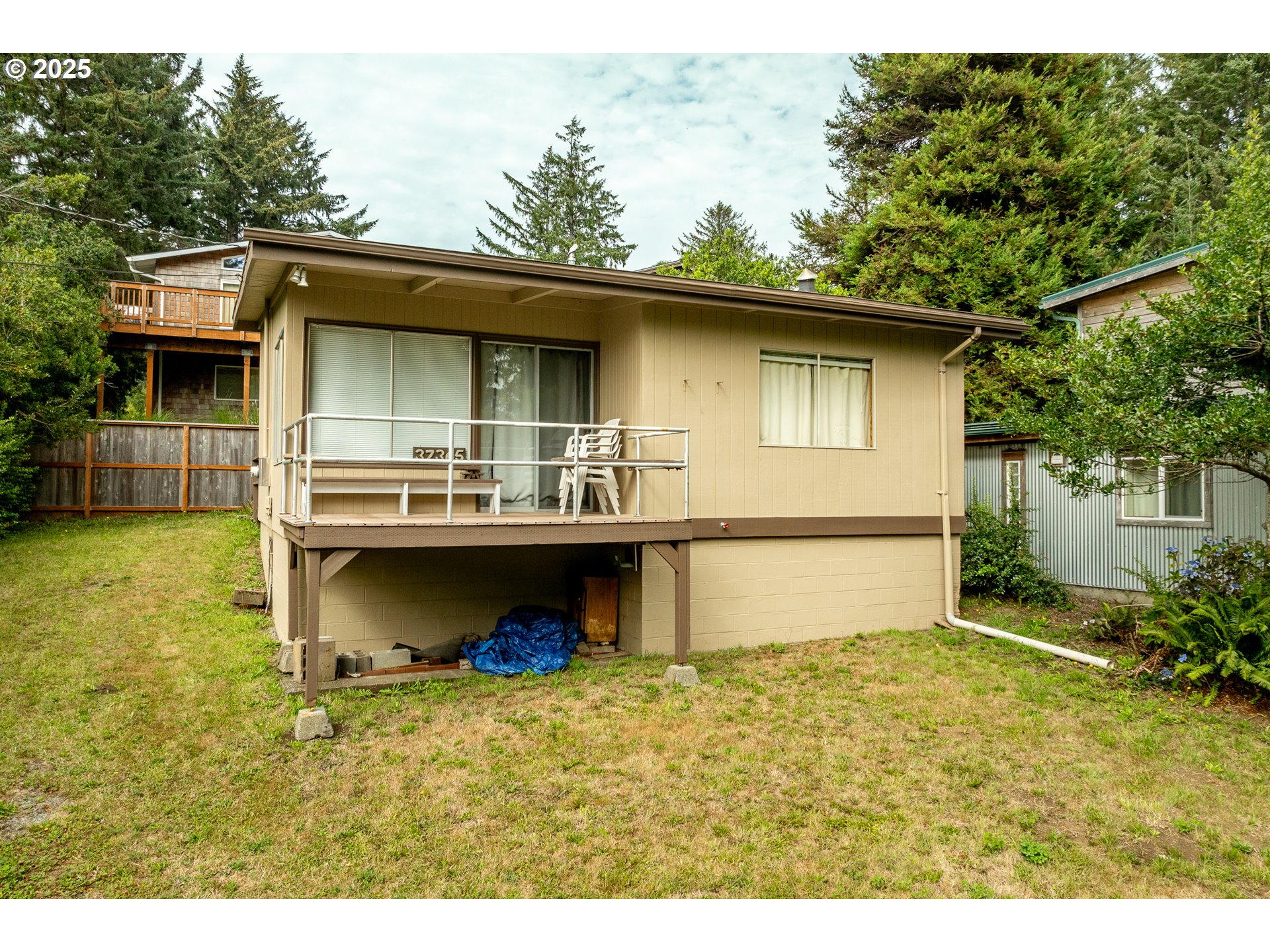 37365 4th Street Nehalem, OR 97131 - Photo 18 of 27 a backyard of a house with garage and outdoor seating
