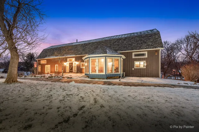 a kitchen with stainless steel appliances kitchen island granite countertop a table chairs in it and wooden floors