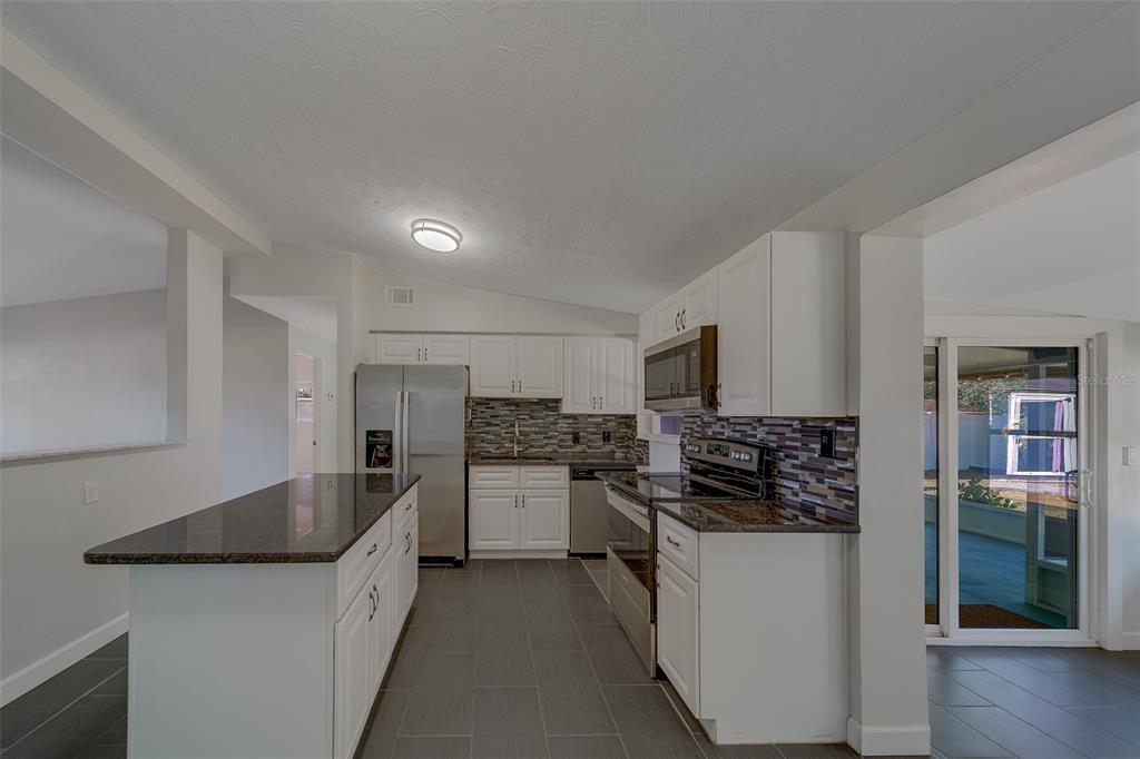 11128 116th Street Largo, FL 33778 - Photo 11 of 50 a kitchen with stainless steel appliances granite countertop a sink stove oven and refrigerator