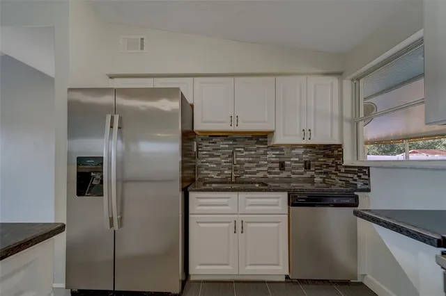 a kitchen with cabinets and stainless steel appliances