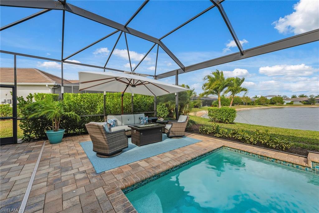 14685 Kelson Circle Naples, FL 34114 - Photo 25 of 50 a view of a patio with couches table and chairs under an umbrella