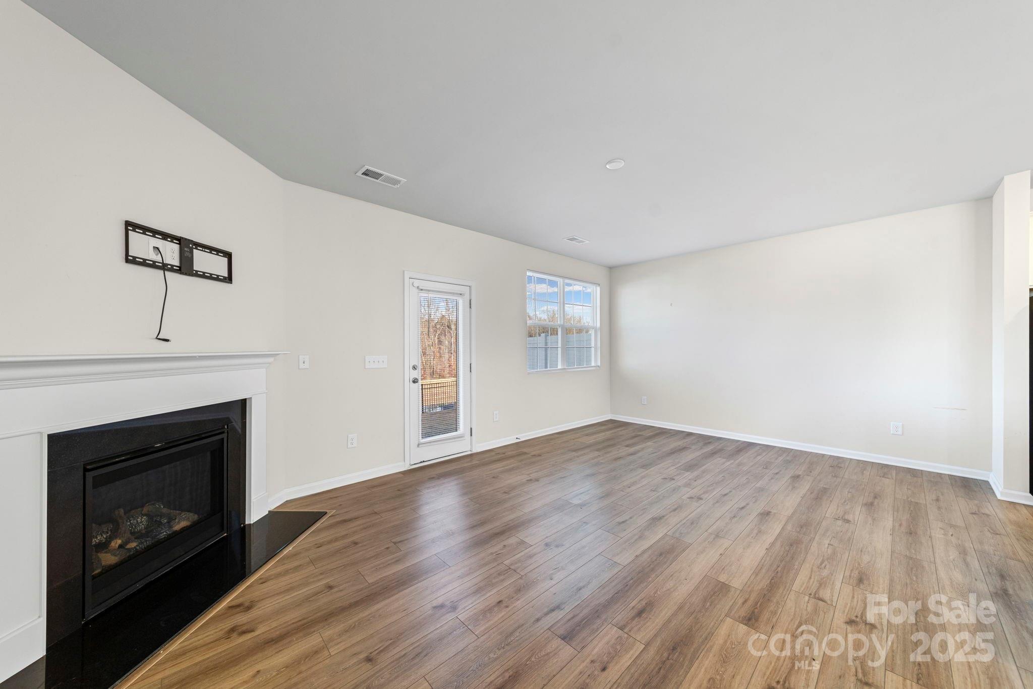 5044 Moss Pine Way Tega Cay, SC 29708 - Photo 15 of 40 a view of empty room with wooden floor and fireplace