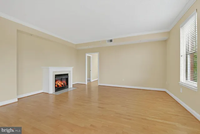 a view of an empty room with a window and a fireplace