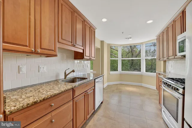 a kitchen with granite countertop a sink and a stove