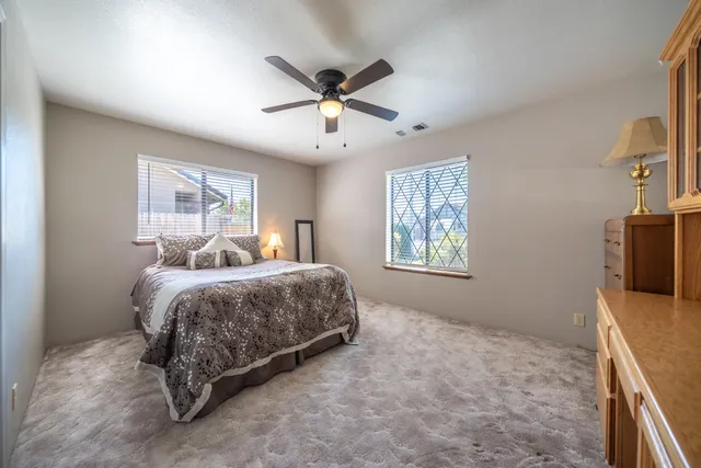 a spacious bedroom with a bed and a flat screen tv