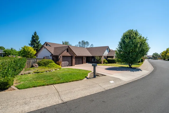 a view of a house with a yard and potted plants