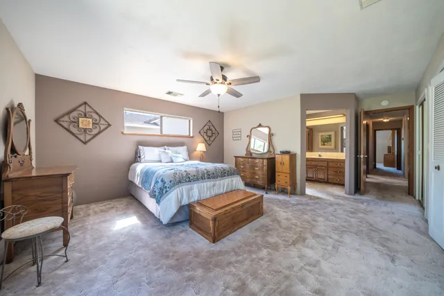 a spacious bedroom with a bed and a chandelier