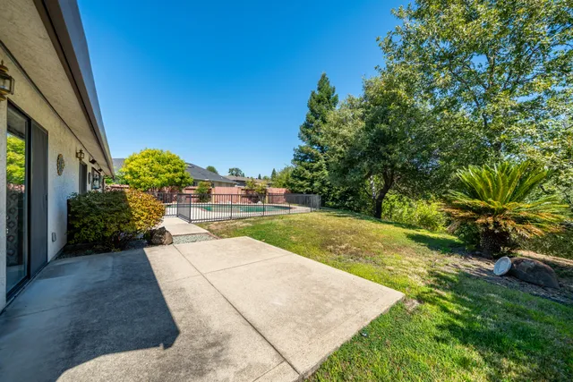 a view of backyard with swimming pool and trees in the background