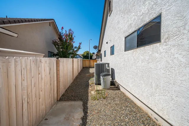 a view of a house with a big yard plants and large trees