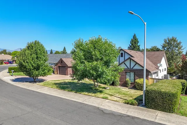 an aerial view of a city with lots of residential buildings and mountain view in back