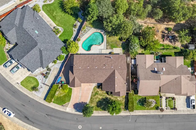 an aerial view of a houses with a yard and lake view