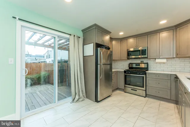 a kitchen with stainless steel appliances granite countertop a refrigerator and a sink
