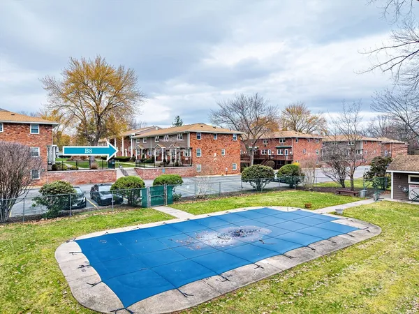 front view of a house with swimming pool and yard