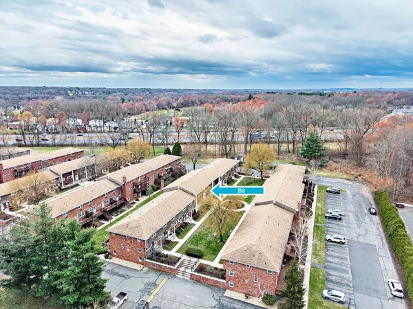an aerial view of a city with lots of residential buildings ocean and mountain view in back