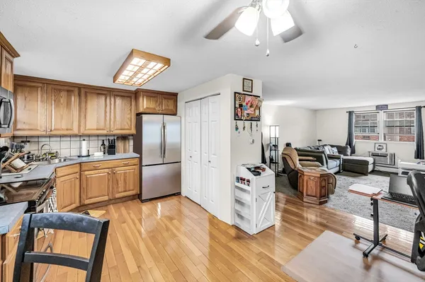 a kitchen with stainless steel appliances wooden floor and large window