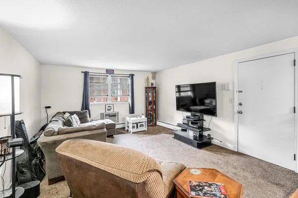 a bedroom with furniture a flat screen tv and a window