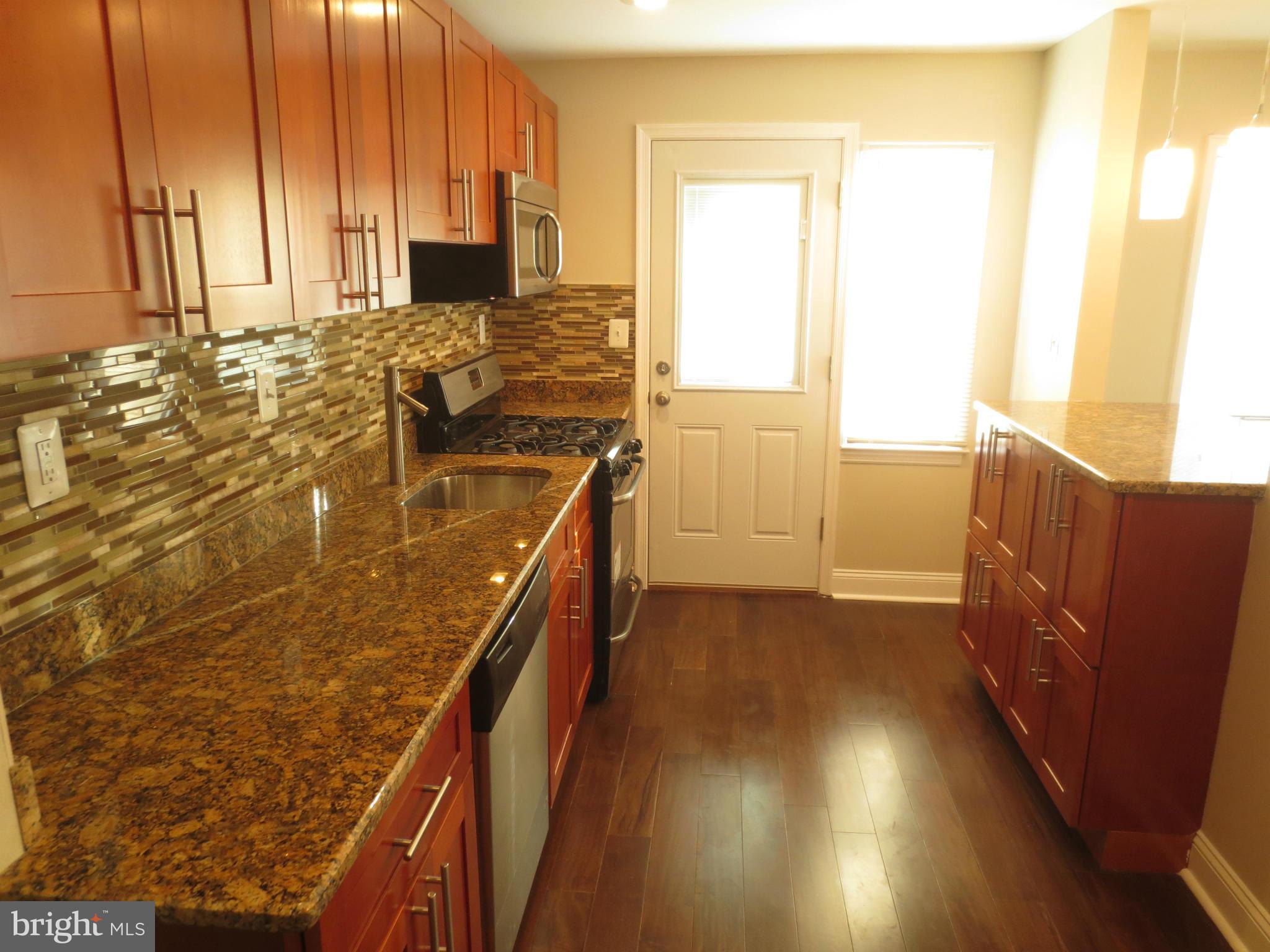 1801 Heathfield Road Baltimore, MD 21239 - Photo 1 of 28 a kitchen with wooden cabinets and sink