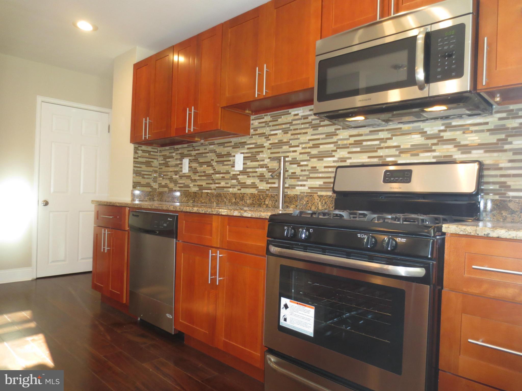 1801 Heathfield Road Baltimore, MD 21239 - Photo 3 of 28 a kitchen with granite countertop a stove top oven and cabinets