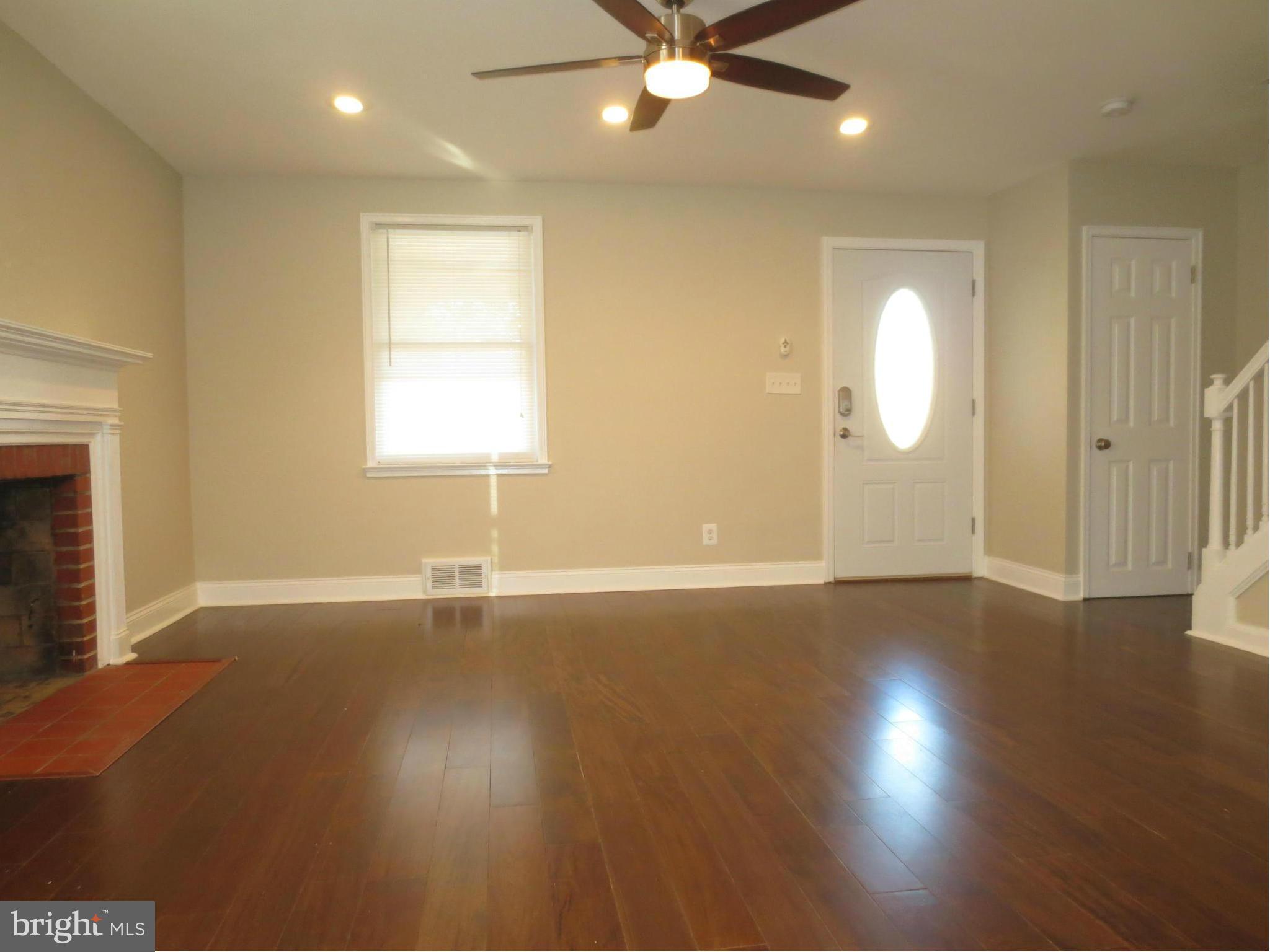 1801 Heathfield Road Baltimore, MD 21239 - Photo 9 of 28 an empty room with wooden floor and windows
