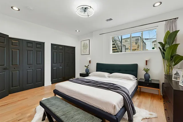a bedroom with a bed and a potted plant