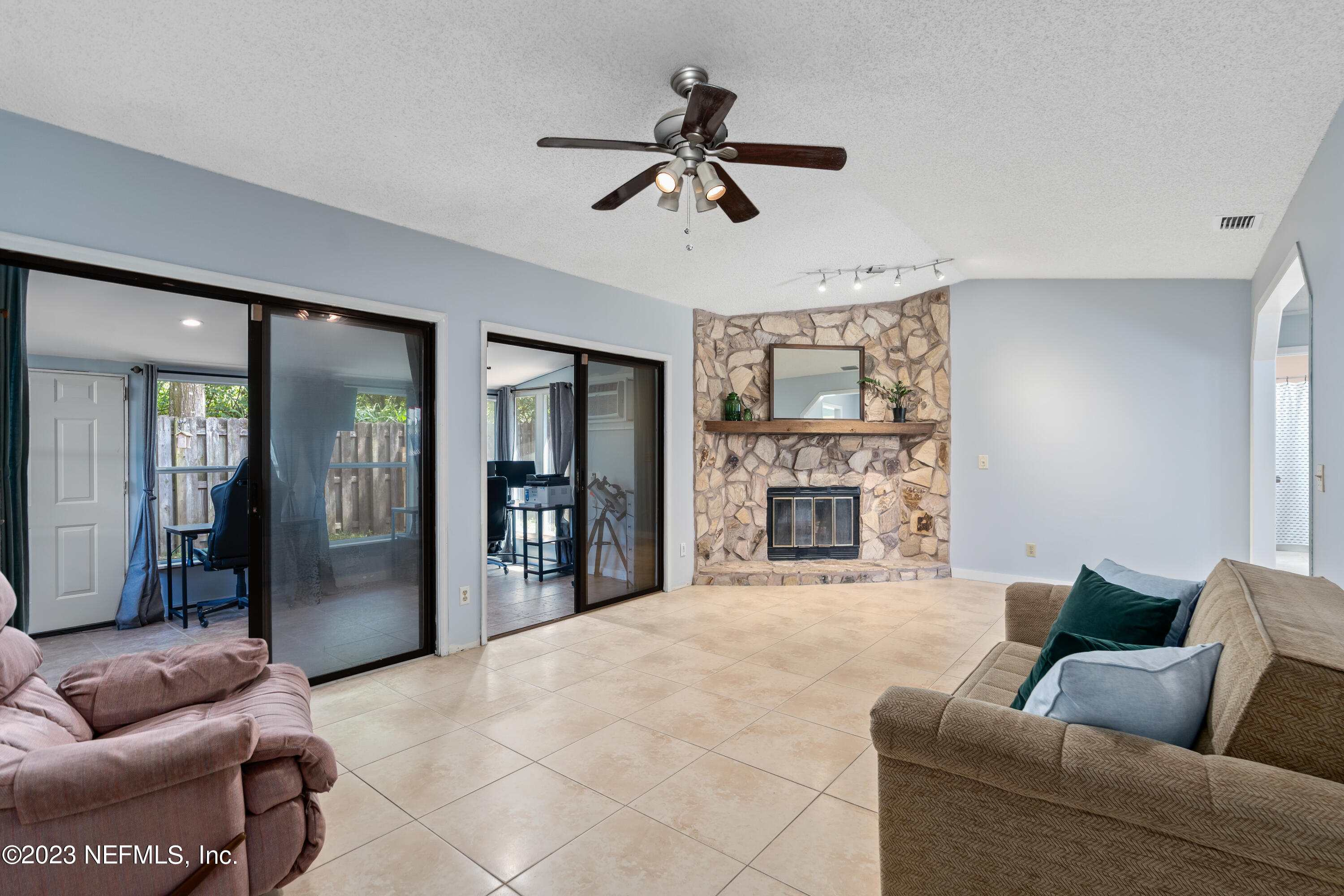 107 Heron Road St. Augustine, FL 32086 - Photo 13 of 39 a living room with furniture a fireplace and a ceiling fan