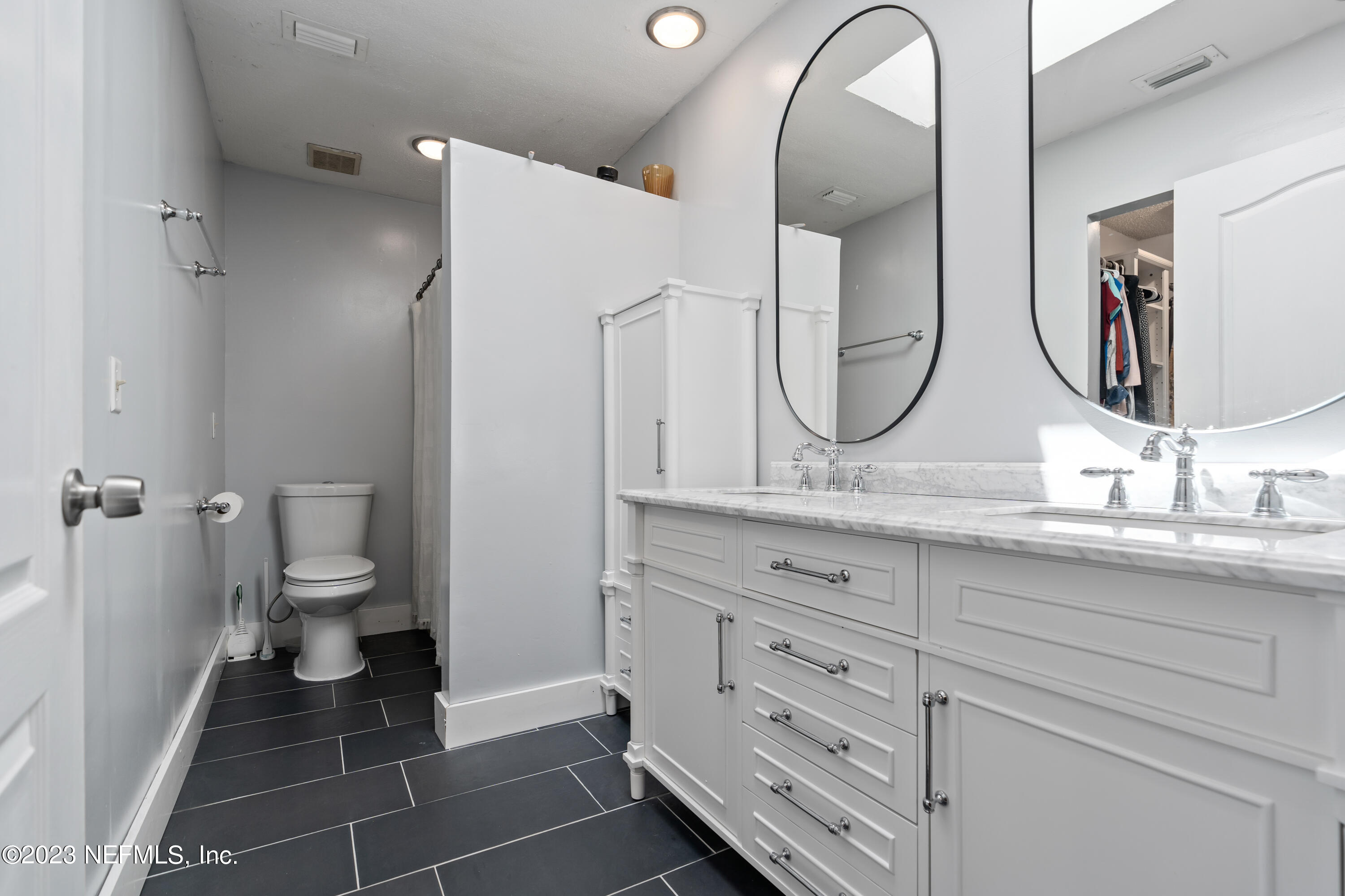 107 Heron Road St. Augustine, FL 32086 - Photo 8 of 39 a spacious bathroom with a granite countertop toilet a sink and a mirror