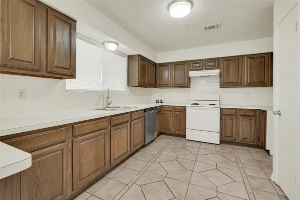 a kitchen with a sink a stove and cabinets