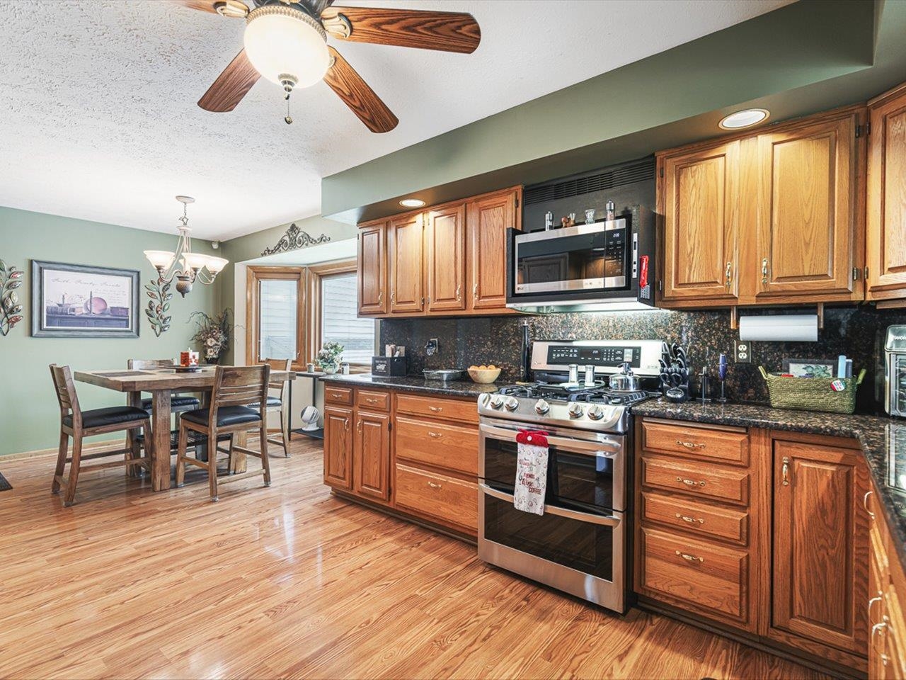 9744 Prairie Lane Belvidere, IL 61008 - Photo 17 of 66 a kitchen with stainless steel appliances granite countertop wooden cabinets a stove a sink and a microwave