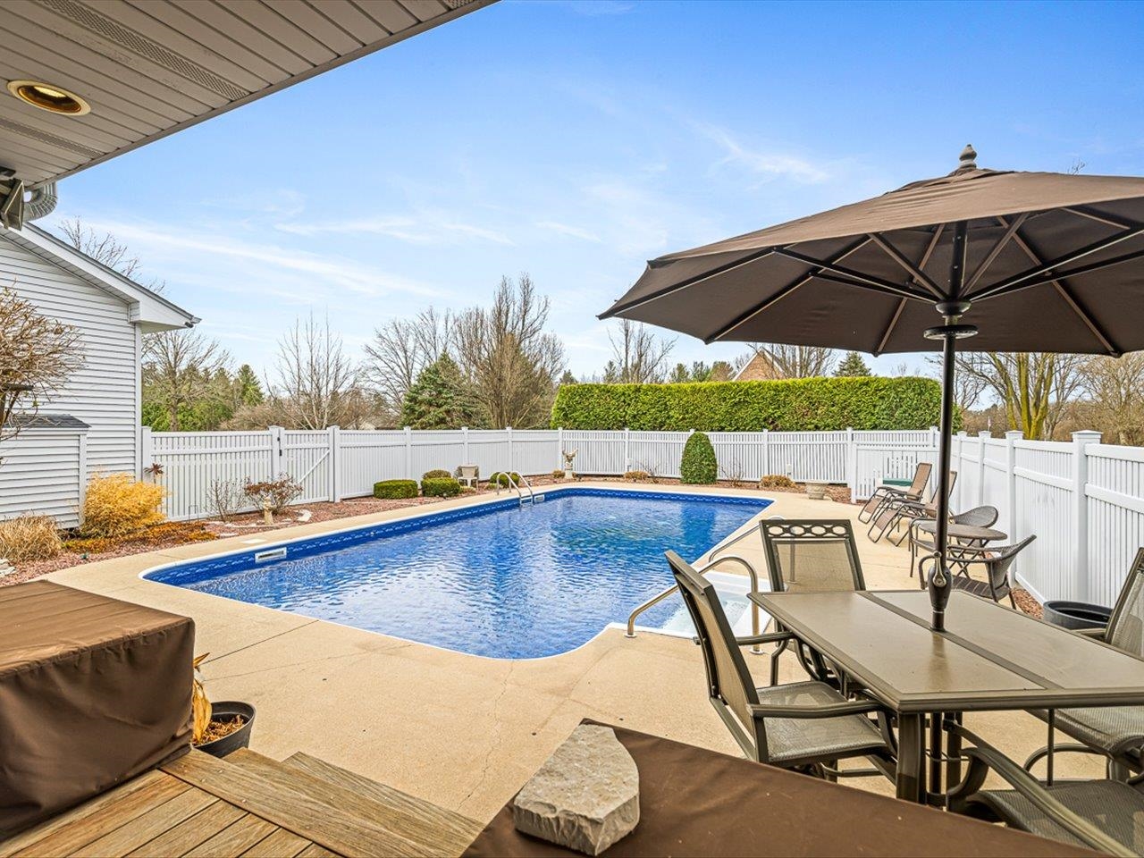 9744 Prairie Lane Belvidere, IL 61008 - Photo 46 of 66 a view of a swimming pool with a table and chairs under an umbrella