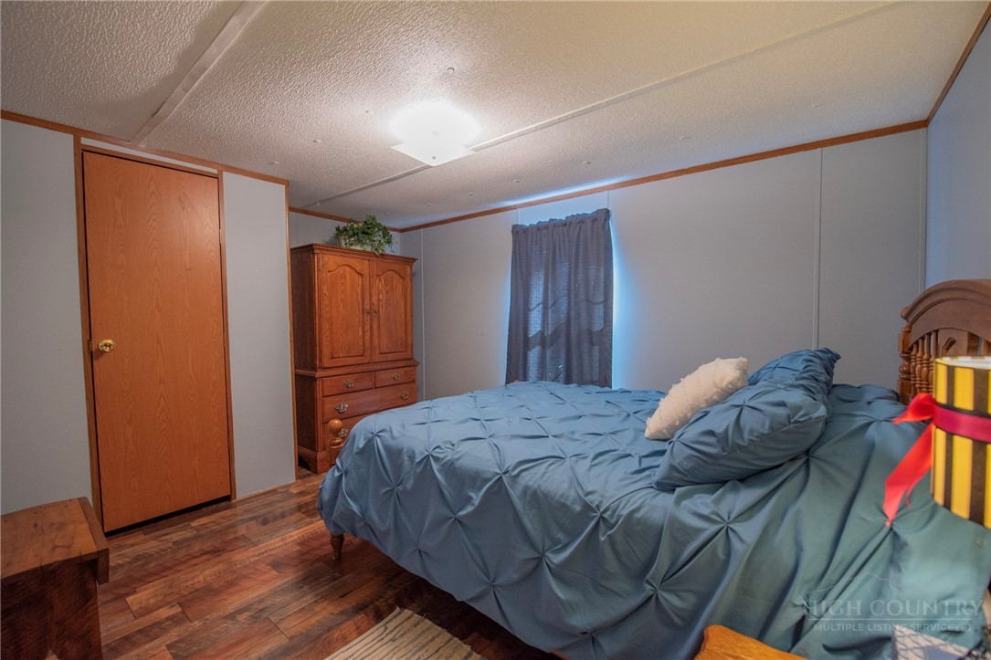 1848 West Mill Creek Road Warrensville, NC 28693 - Photo 39 of 50 a bedroom with a bed and wooden floor