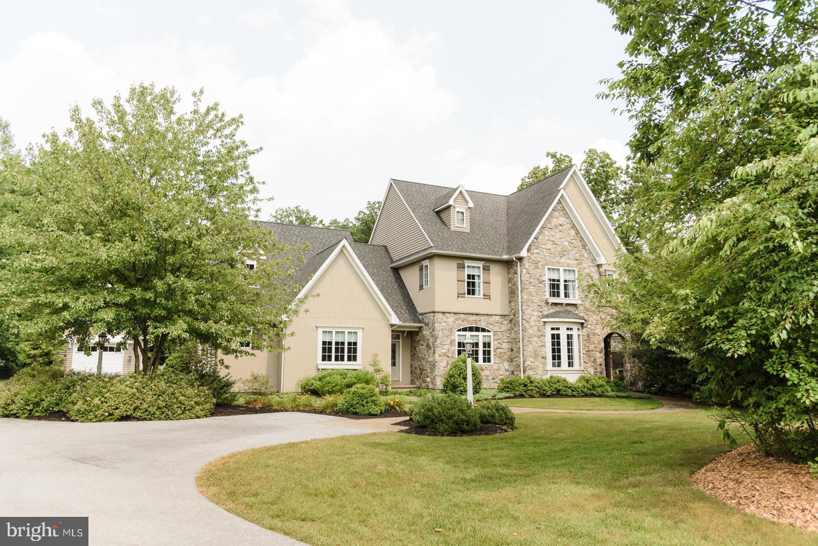 Charming stone-front home amid lush greenery.