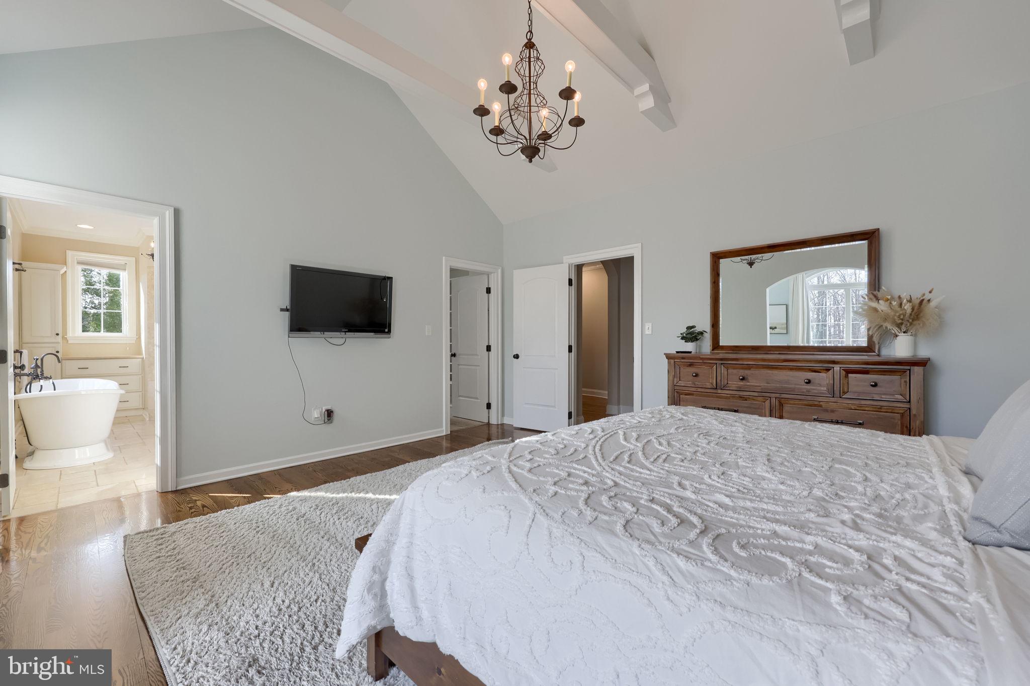 521 Meetinghouse Road Gap, PA 17527 - Photo 38 of 79 a bedroom with a large bed a flat tv screen and a chandelier
