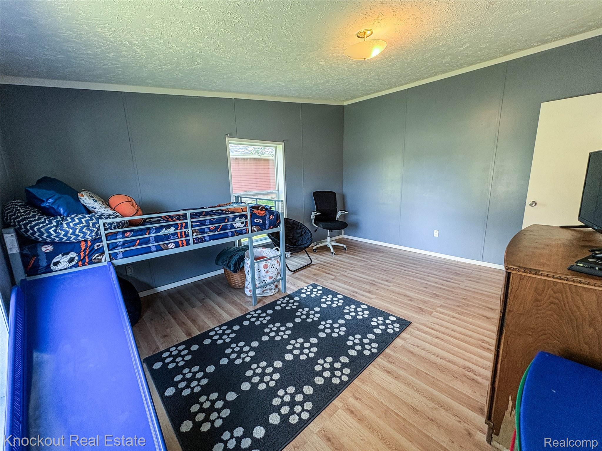 7760 Bell Road Birch Run, MI 48415 - Photo 46 of 68 Spacious room featuring wood-finish flooring, a single window providing natural light, and a ceiling-mounted light fixture