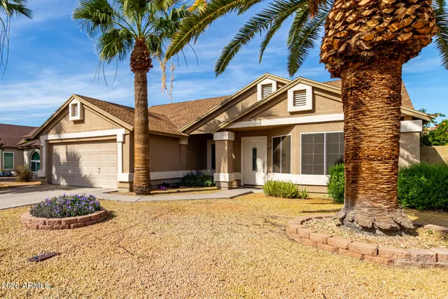a front view of a house with a yard and potted plants
