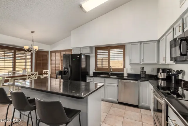a kitchen with stainless steel appliances granite countertop a sink a stove and refrigerator