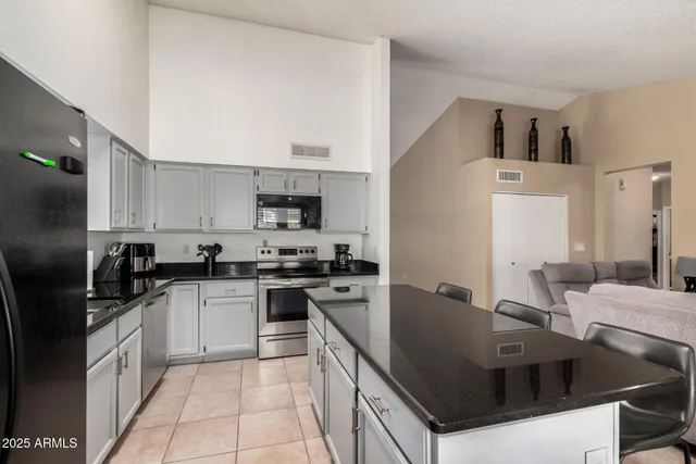 a kitchen with stainless steel appliances granite countertop a sink a stove and refrigerator